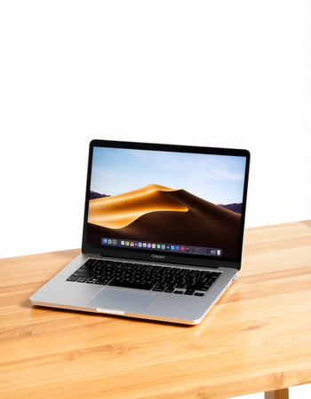 Laptop on a wooden table with a white background.