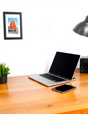 Laptop with blank screen on wooden table and white wall background.の写真素材
