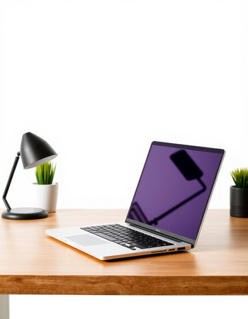 Laptop with blank screen on wood table and white wall background.