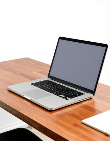 Laptop computer with blank screen on wooden table isolated on white background
