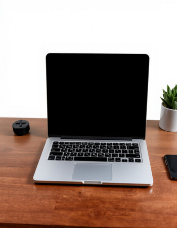 Laptop with blank screen on wood table and white wall background.