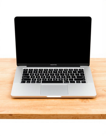 Laptop with blank screen on wooden table isolated on white background.