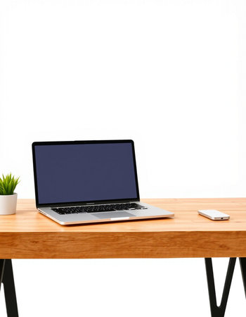 Laptop on a wooden table with a white wall in the background