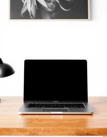 Laptop with blank screen on a wooden desk in a modern office