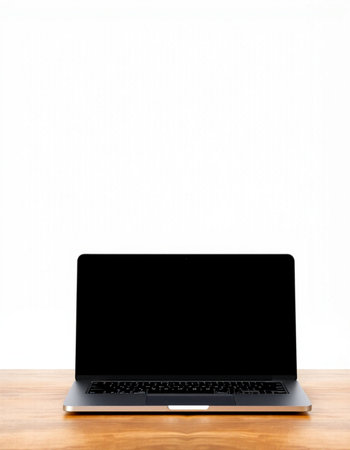 Laptop with blank screen on wooden table isolated on white background.