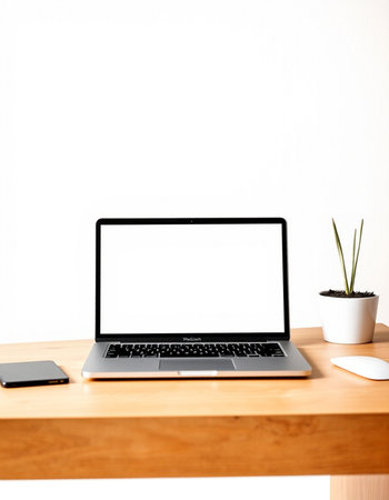 Laptop with blank screen on wooden table and white wall background.