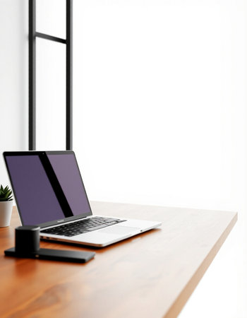 Laptop on a wooden table with a white wall in the background