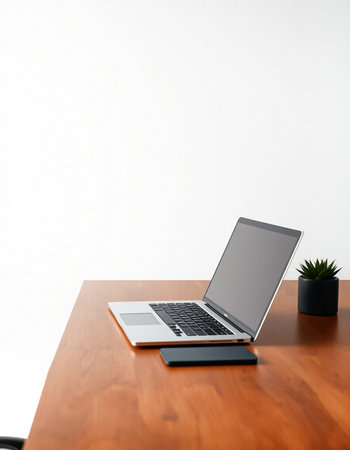 laptop computer on wood desk with white wall background, stock photo