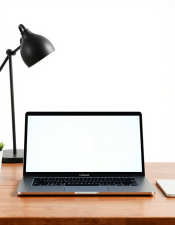 Laptop computer with blank screen on wooden table and lamp on white background