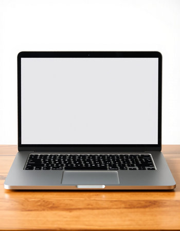 Laptop computer with blank screen on wood table and white wall background