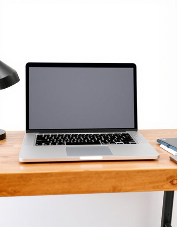 Laptop with blank screen on wooden table in office, stock photo