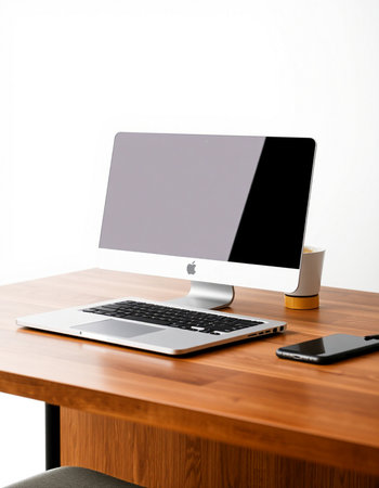 Modern workspace with blank screen computer monitor, coffee cup and mobile phone on wooden table