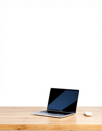 Laptop computer on wooden table with white wall background, stock photo