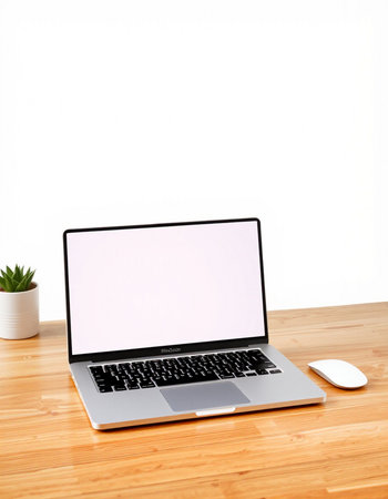 Laptop with blank screen on wooden table and white wall background.