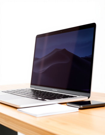 Laptop with blank screen on wood table in office