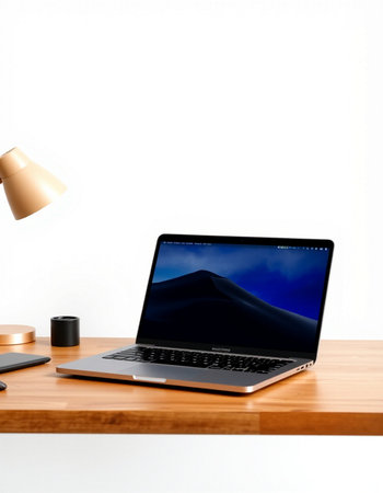 Laptop on a wooden table with a lamp and a cup of coffee