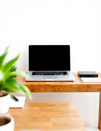 laptop with blank screen on wooden desk at home office, stock photo