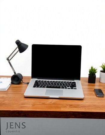 Laptop with blank screen on wooden table with white wall background.の写真素材