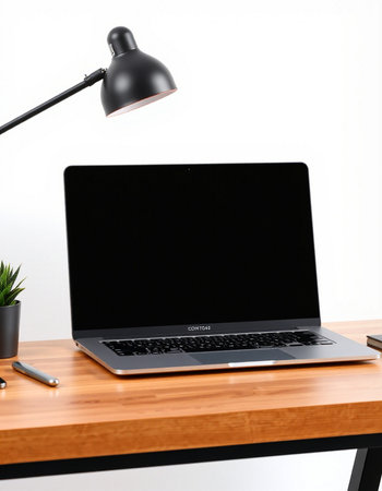 Laptop on wooden desk with black screen and black lamp.の写真素材