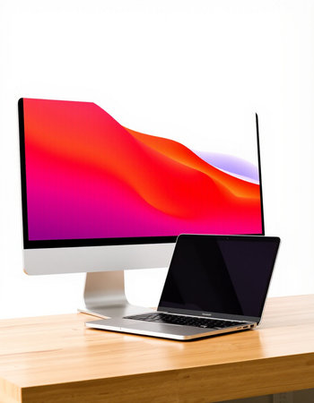 Computer with colorful screen and laptop on desk isolated on white background.