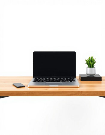 Laptop with blank screen on wooden table and white wall background.