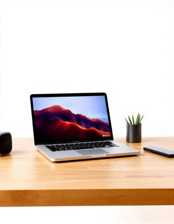Laptop on a wooden table with a white wall in the background