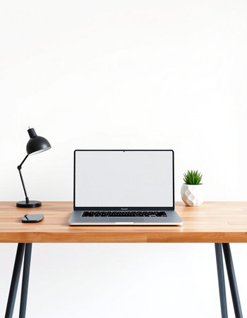 Laptop with blank screen on wooden table and lamp on white wall background