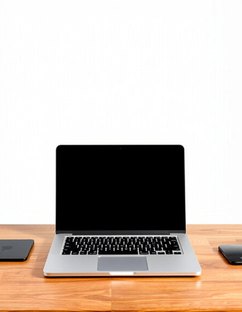 Laptop with blank screen on wooden table and white wall background.の写真素材
