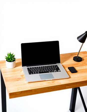 Laptop on a wooden table with a lamp and a plant.