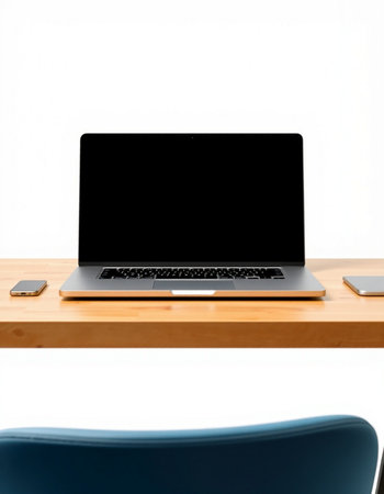 Laptop on wood desk with white wall background and copy space.