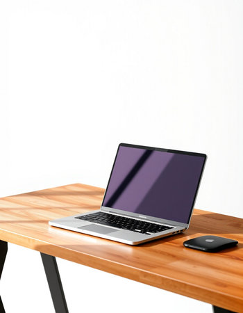 Laptop on a wooden table with a smartphone on a white background