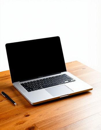 Laptop on a wooden table with a pen on a white background