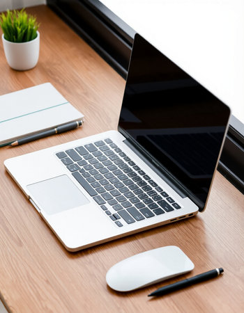 Laptop with blank screen on wooden table in office, stock photo