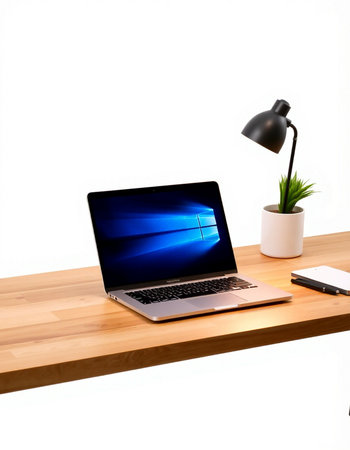 Laptop on wooden desk and white wall background.