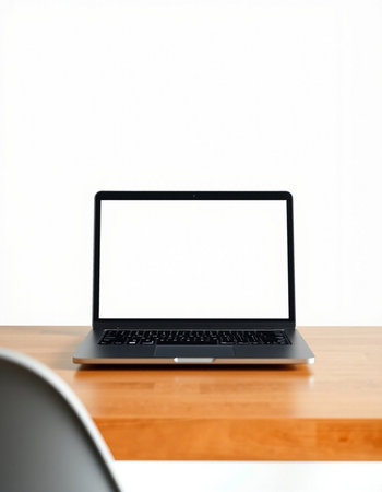 Laptop with blank screen on wooden desk and white wall background.の写真素材