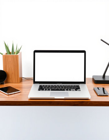 Modern workspace with blank screen laptop computer, mobile phone and coffee cup on wooden table.