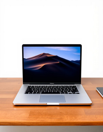Laptop on wooden desk with white background and sand dune.