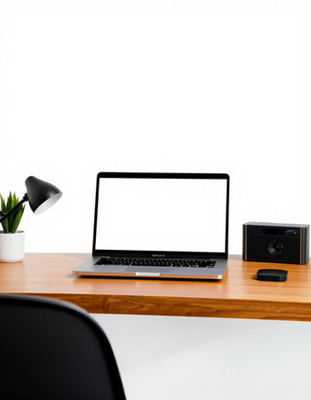 Laptop with blank screen on wooden table and white wall background.の写真素材
