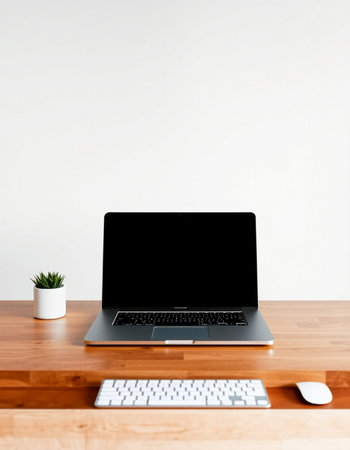 Laptop with blank screen on wooden desk and white wall background.の写真素材