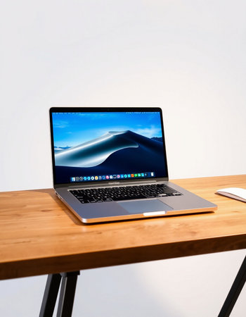 Laptop on wood table with white wall background and copy space.