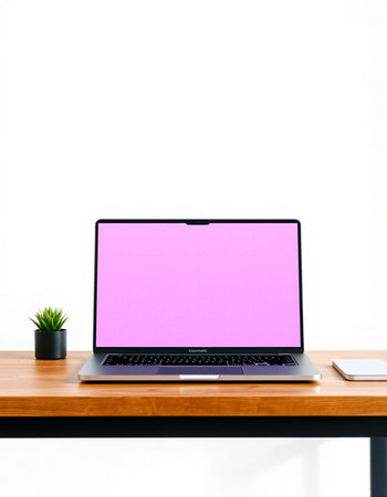 Laptop with blank pink screen on the wooden desk and white wall backgroundの写真素材