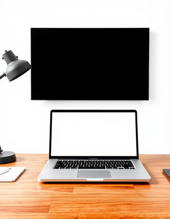 Laptop with blank screen on wooden table and lamp on white wall background