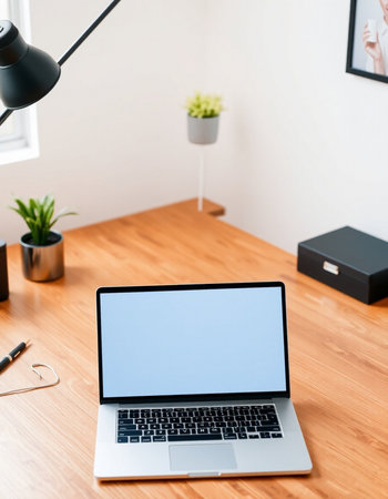 Laptop with blank screen on wooden table in office, stock photoの写真素材