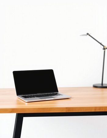 Laptop on wooden table with lamp on white wall background. Workplace conceptの写真素材