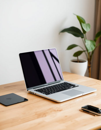 Laptop with blank screen on wooden table in office, stock photo
