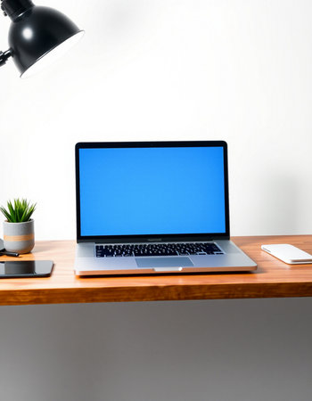 Laptop with blank screen on wooden table and office accessories on white wall backgroundの写真素材