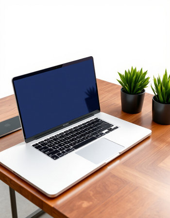 Laptop with blank screen on wooden table