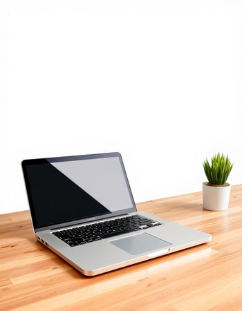 Laptop on a wooden desk with a white wall in the background
