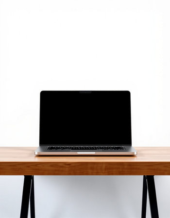 Laptop on wooden table with white wall background. Laptop with blank screen.の写真素材