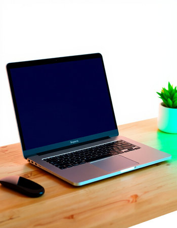 Laptop on a wooden table with a green plant in a potの写真素材